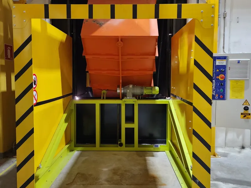 Volteador elevando un contenedor para la descarga
